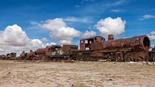 Abandoned and rusted locomotives under a clear sky with white clouds, old rusty locomotives at the