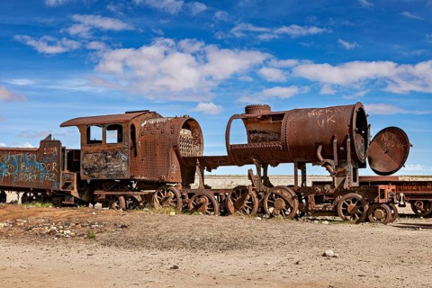 Rusty locomotive shows clear damage in an abandoned desert landscape, old rusty locomotives at the