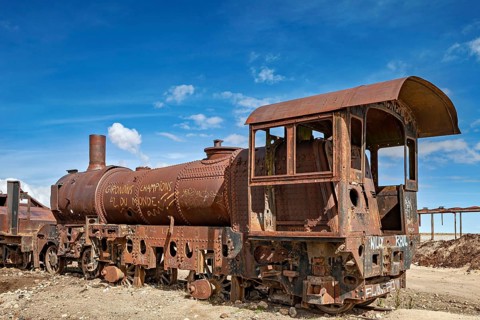 Rusted steam locomotive in an abandoned area under a blue sky, old rusty locomotives at the train