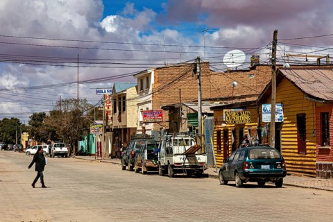 Street scene with parked cars and clouds in the sky in a small town, the town of Uyuni in Bolivia