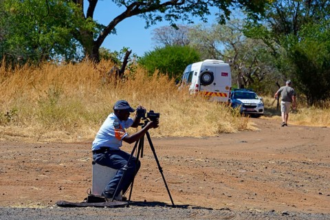 A policeman controls traffic with a camera on a tripod on the side of the road, man must pay fine