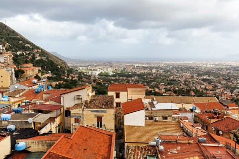 View of red tile roofs of the city of Monreale, Palermo on the horizon, Monreale, Sicily, southern