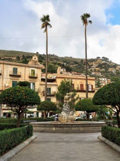 Tall palm trees, central fountain, hedges and orange trees, Piazza Vittorio Emanuele, Monreale,