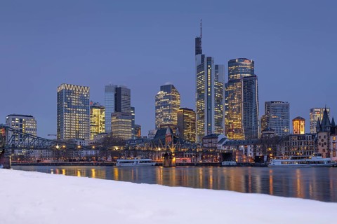 The towers of the Frankfurt banking skyline rise behind the snow-covered banks of the Main,