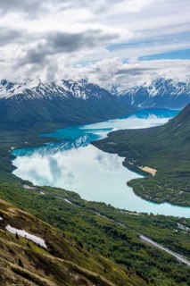 View of snowy mountains in spring and turquoise Kenai Lake with reflection, Slaughter Ridge Trail,