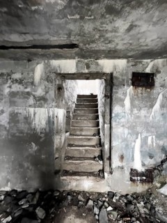 Old Wehrmacht anti-aircraft bunker from the Second World War with worn stairs in a dilapidated,
