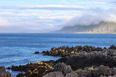 Atmospheric coastal landscape with cloudy sky over a vast sea on the coastal road in the north of