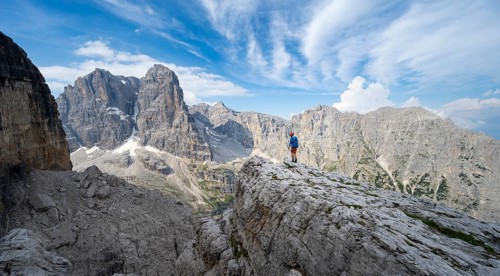 Mountaineers on a rock in front of picturesque mountain landscape with rocky peaks, Via Ferrata