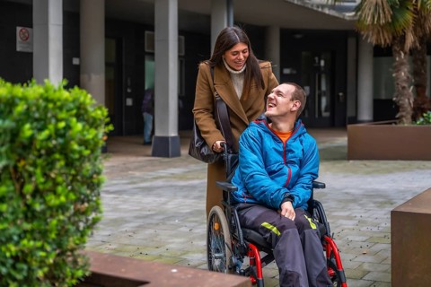 Woman and man with disability smiling outdoors, focusing on happy interaction, personal growth,