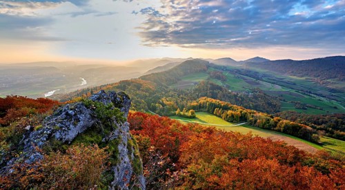 View from the Gisliflue of an autumn-colored forest, behind the Jurassic foothills with water fluh
