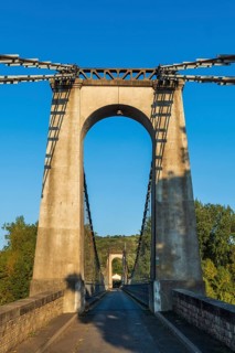 Suspension bridge of Coudes village on river Allier. Puy de Dome. Auvergne Rhone Alpes. France