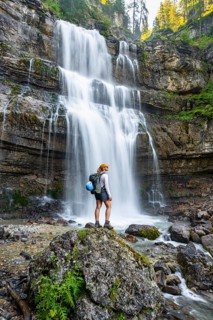 Young woman in front of Cascata di Mezzo waterfall, long exposure, Vallesinella, Brenta, Trentino,