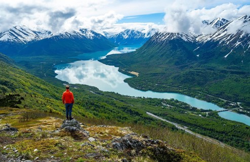 Climber enjoying the view, Slaughter Ridge Trail, view of snowy mountains and turquoise blue Kenai