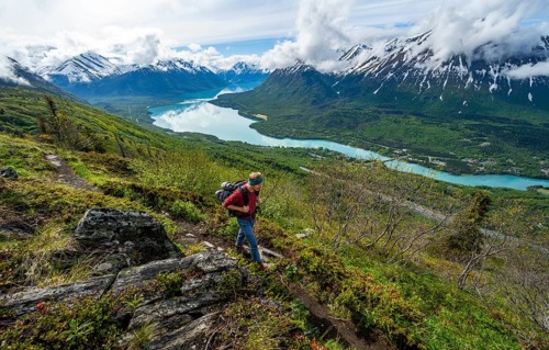 Climbers on a hiking trail, Slaughter Ridge Trail, view of snowy mountains and turquoise lake Kenai