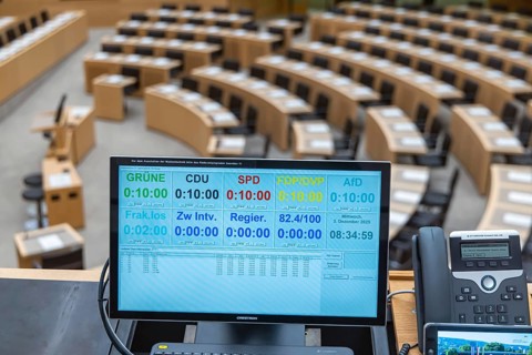 Plenary hall deserted with the seats of deputies and the government bank. Behind it is the