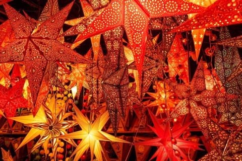 December 22, 2025, many glowing Christmas stars hanging at a market stall near St. Paul's Church,