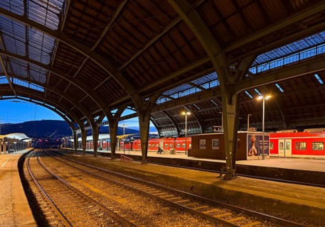 Empty platform with the two-nave platform hall and regional express in the evening, central railway