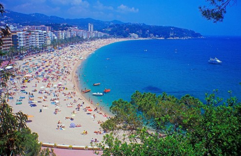 Skyscrapers, people, boats, trees, Lloret de Mar beach on the Costa de Maresme near Barcelona,