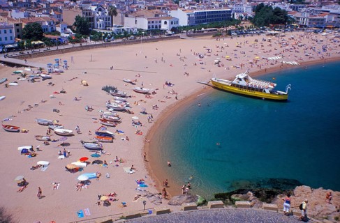 Houses, people, sightseeing boat on Tossa de Mar beach, Costa Brava, Spain, June 1999, vintage,