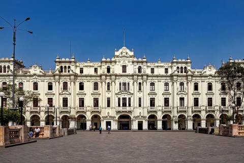 Large historic building in an open square with bright blue sky, Downtown Lima in Peru