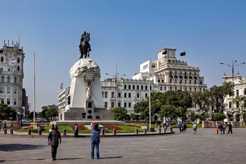 Equestrian monument on a large square in front of imposing historic buildings, Downtown Lima in