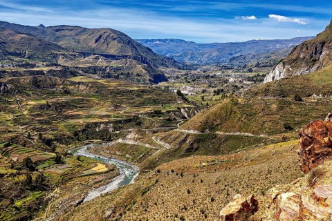 River valley with terraces and mountains under sweeping skies, the landscape of the Colca Canyon in