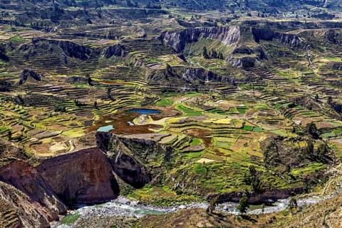 Large-scale view of terraced fields in a vast mountain landscape with a river, The landscape of the
