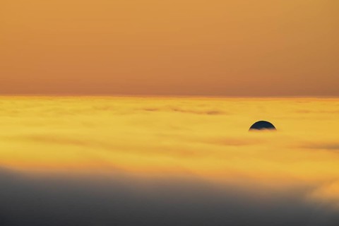 View from Mount Domen. Thick sea fog hangs over the Barents Sea and the midnight sun shines in an