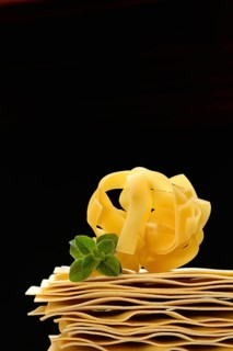 Uncooked lasagna leaves and fettuccine, noodle nest