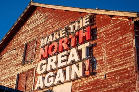 Red fishing building with the inscription Make the North great again at Vardö harbour, Vardø,