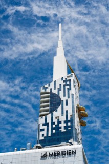 Modern high-rise building with distinctive design against a blue sky, Batumi Tower with Ferris