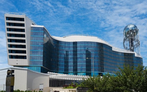 Modern building with wave-like design and glass façade under blue sky, business loft, right