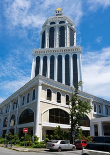A magnificent tower of blue and white architecture rises into the sunny sky of a busy city, Hotel