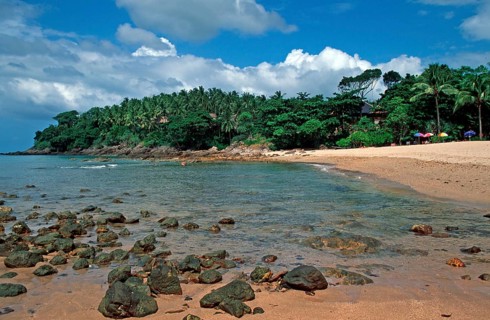 Palm trees, umbrellas, beach at Coral Beach Resort on the island of Ko Lanta, Thailand, December