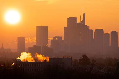 The sun rises behind Frankfurt's banking skyline, Frankfurt am Main, Hesse, Germany