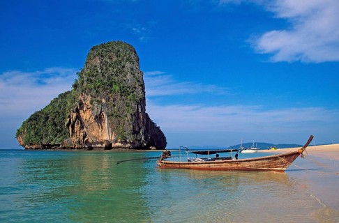 Rocks in the sea and longtail boat on Pranang Cave beach, two years in front of the tsunami, Krabi,