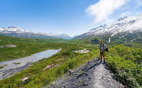 Hikers on glacial moraine, view of the vast Tsina River valley with mountains, Worthington Glacier