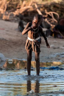 Himba child washing with water on a river, traditional Himba, Kaokoveld, Kunene, Namibia