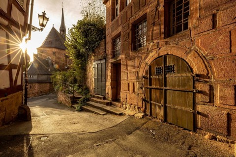 Historic alley with half-timbered houses and church in sunlight with a quiet atmosphere, The