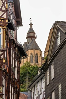 Detailed architecture shows half-timbered houses and a church above the roofs, The historic old