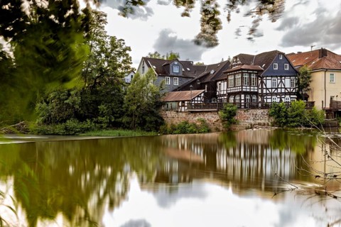 Half-timbered houses on the lake with dramatic clouds and reflections in the water, The historic