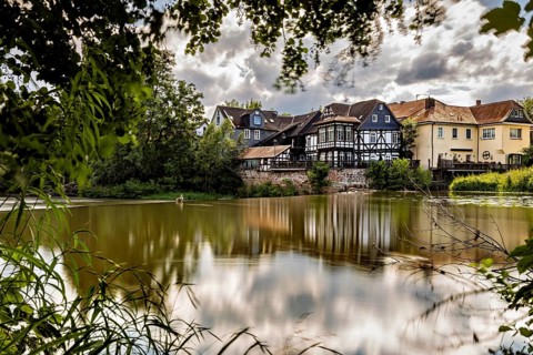 Half-timbered houses on the lake under cloudy skies, surrounded by nature, The historic houses of