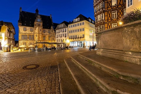 Square with historic flair, surrounded by half-timbered architecture, in the evening with paved