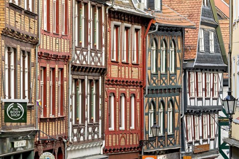 Detailed, colorful half-timbered facades in a cramped old town alleyway, The historic old town of