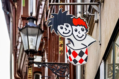 Lantern next to a colorful advertising sign in urban areas with traditional building facades, The
