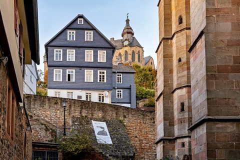 Church over historic city walls in warm evening light, The historic city center of Marburg in Hesse