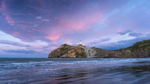 Castlepoint Beach, ocean and lighthouse on a rock, evening, sunset, dramatic sky. Castlepoint,