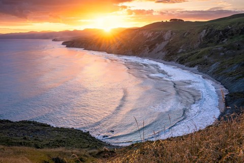 Wairarapa coast at sunset. Sea, mountains, backlight. Castlepoint, Wairarapa Coast, Wellington