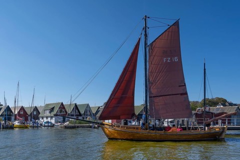 Zeesboot, former historic fishing boat, leaves the port of Ahrenshoop, blue sky, Darß,