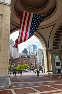 American flag fluttering, distinctive archway, Boston Harbor Hotel, Rowes Wharf, passers-by,